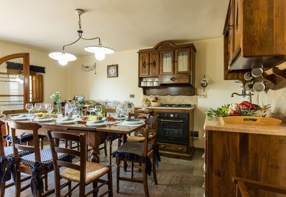 The kitchen with dining table and exit to the outside – Dimora La Torre di Bussotto 