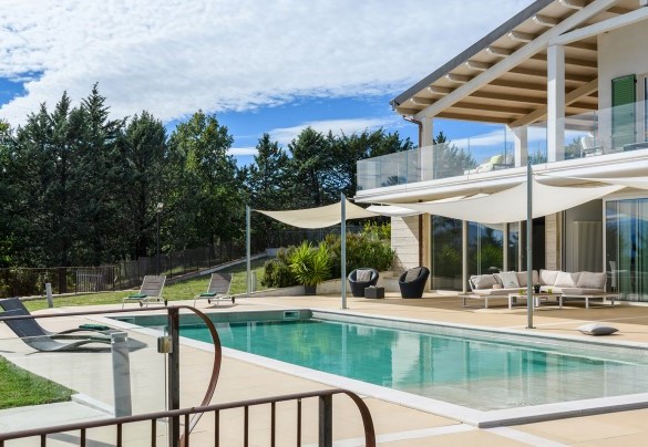 Outdoor pool with sun loungers and breathtaking views of the surrounding hills - Dimora Montefalcone