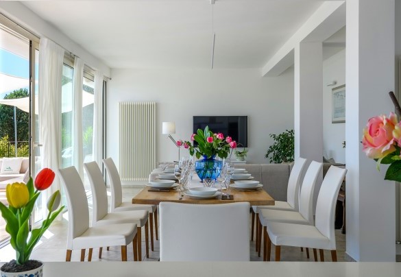 Modern dining area with a wooden table in a bright and airy setting - Dimora Montefalcone