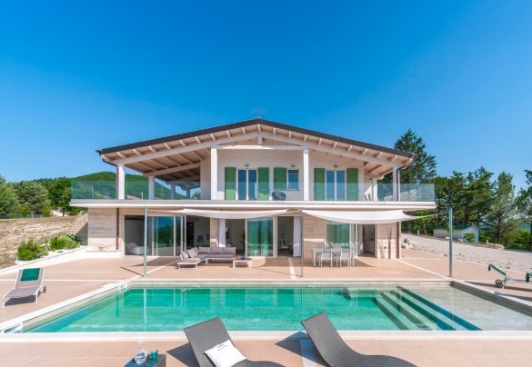 Elegant facade of the villa with a terrace, lounge area and pool, surrounded by greenery - Dimora Montefalcone