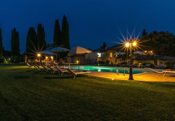 La zona piscina illuminata di notte e sullo sfondo il casale - Dimora Rovena  