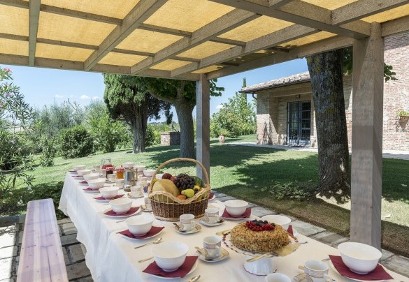 La zona pranzo esterna allestita con tavoli e panchine - Dimora Rovena