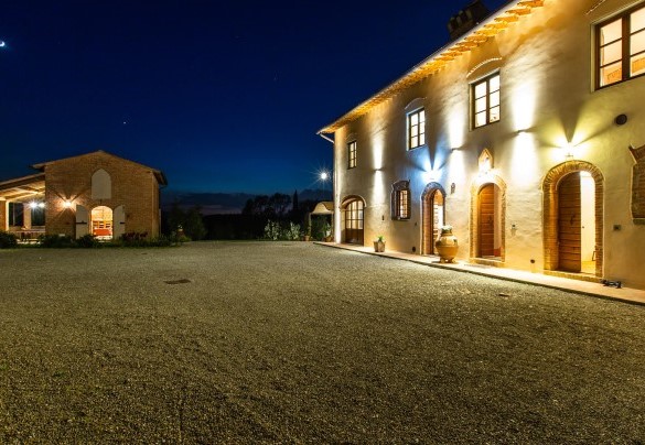 La villa e il fienile avvolta da luci dai toni caldi e soffusi – Dimora San Germano