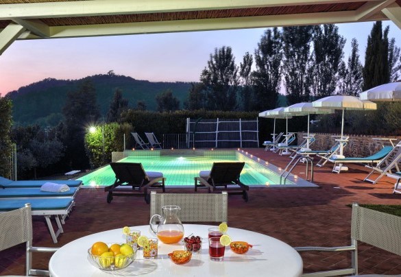 Il gazebo di legno con tavolo e poltroncine nell’area piscina – Dimora San Jacopo
