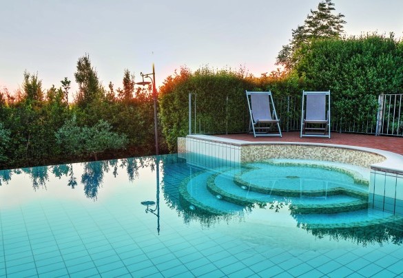 Il bordo della piscina è in cotto ed è rivestita con piastrelle color sabbia – Dimora San Jacopo