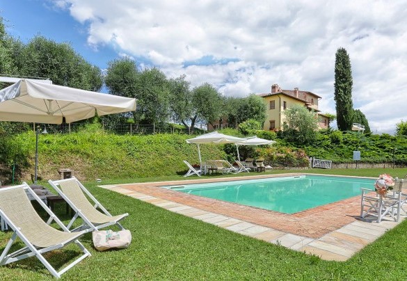 La piscina nel verde del parco, con solarium attrezzato e il casale sullo sfondo – Germagnana 