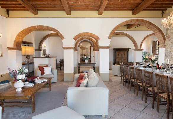 Il grande salone con camino e sala da pranzo con accesso, tramite porta finestra, sull’area pranzo esterna – Guado al Sole