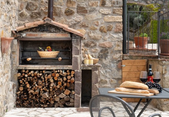 Il barbecue in pietra adiacente alla zona pranzo esterna – Guado al Sole