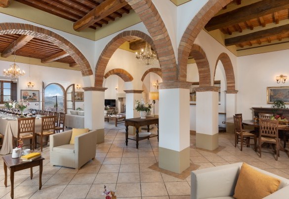 Il grande salone con camino e sala da pranzo con accesso, tramite porta finestra, sull’area pranzo esterna – Guado al Sole