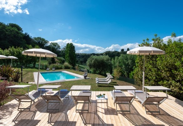 The solarium area, partly lawn and partly wood, is equipped with sunbeds, umbrellas, tables and a porch swing –  I Lauri