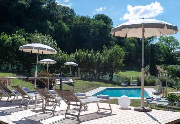 The solarium area, partly lawn and partly wood, is equipped with sunbeds, umbrellas, tables and a porch swing –  I Lauri	