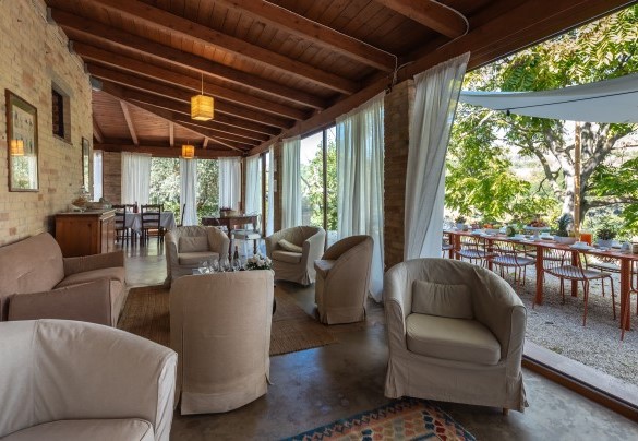 The wooden pergola has sofas and armchairs for guests to fully enjoy the view of the park –  I Lauri	