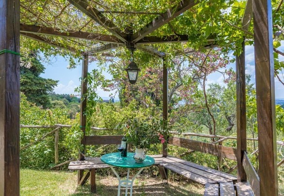 The covered pergola with table just outside the Famrhouse of I Mandorli
