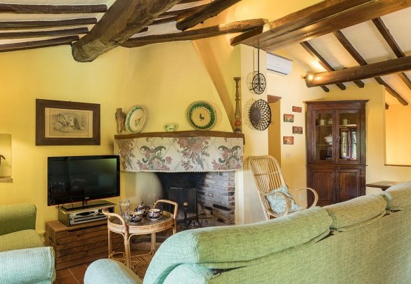 Living room on the first floor of the Farmhouse with sofas and tabe and fireplace