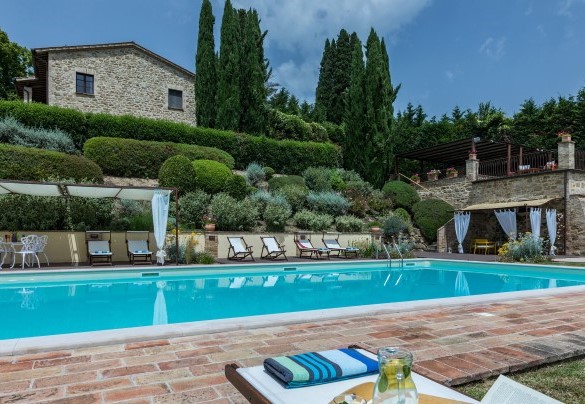 La piscina e sullo sfondo il casale - Il Borgo