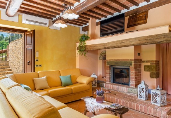 living room on the ground floor with a fireplace and TV - Il Casale Di Manuele