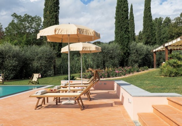 The solarium area, partly terracotta and partly lawn, equipped with sunbeds, deckchairs and umbrellas – Il Cerreto