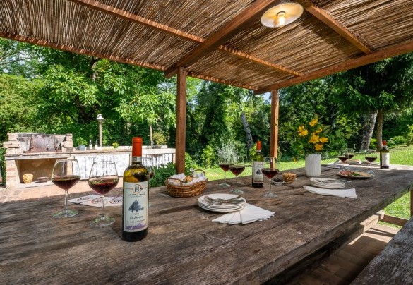 La zona pranzo esterna sotto alla pergola dell’annesso, servita dal barbecue in muratura - Il Molinaccio