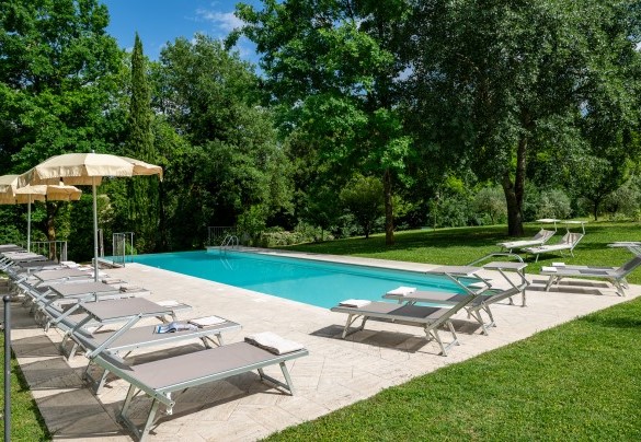 L’area solarium pavimentata in travertino ospita lettini e ombrelloni - Il Molinaccio