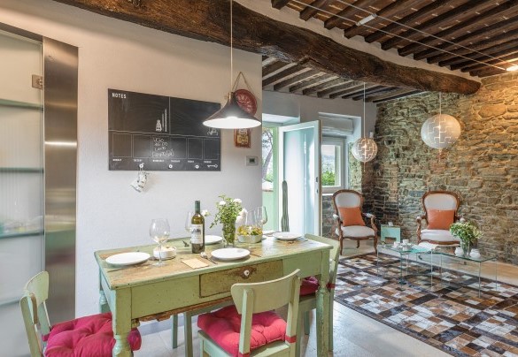 The open-plan sitting area with satellite TV and kitchen with dining table – Il Nido