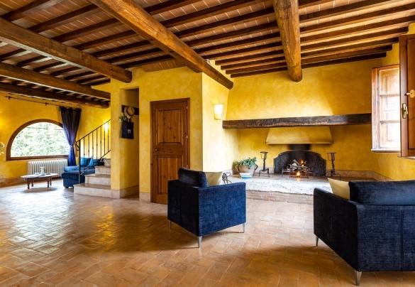 The room with fireplace divided into a living room, dining room and kitchenette on the ground floor in the main house B - Il Poderuccio