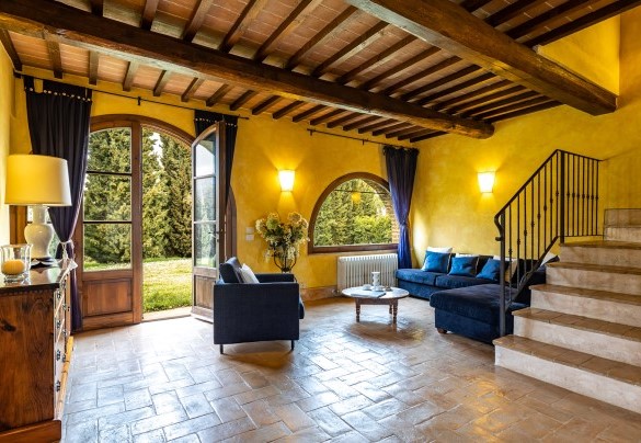 The room with fireplace divided into a living room, dining room and kitchenette on the ground floor in the main house B- Il Poderuccio