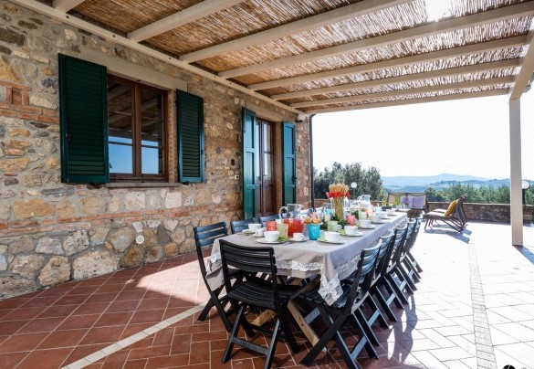 La zona pranzo esterna sotto la pergola, allestita con tavolo e sedie - Il Poggiarellino 