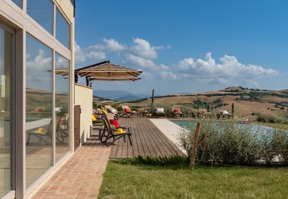 La piscina ha un ampio solarium in doghe di legno di larice - Il Poggiarellone  