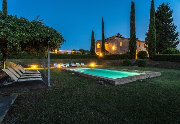 The swimming pool and in the background the house illuminated at night - Il Poggio alle Trese