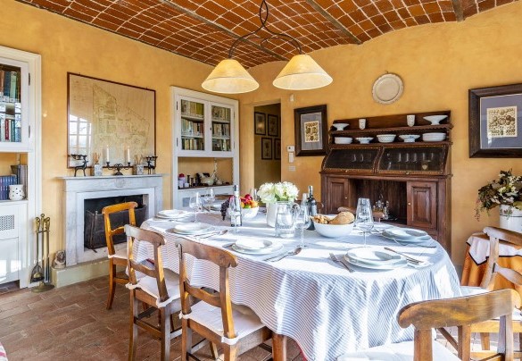 La sala da pranzo con soffitto a volta, camino e angolo salotto creano una calda atmosfera - Il Roseto