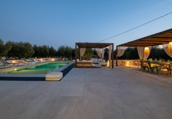Il salottino esterno e la zona pranzo con affaccio sulla piscina al tramonto - Kapoka