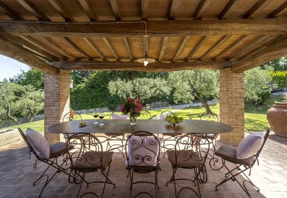 Il portico con tavolo da pranzo all'ingresso del casale - L'Oliveta