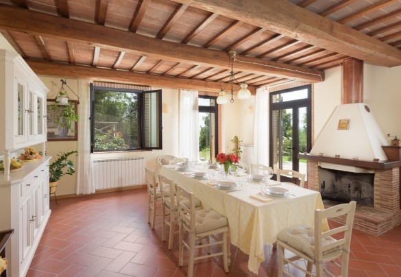 La sala da pranzo, dove è situato il caminetto con cucina accessoriata – L’Ovile 