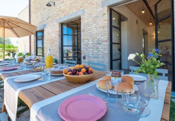 Outdoor dining area furnished with tables and chairs, ideal for breakfast and meals in the open air in total relaxation - La Buona Maniera