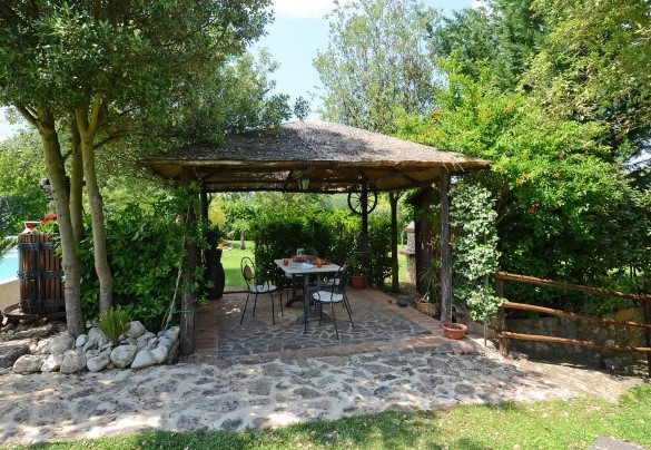 Pergola equipped with table and chairs located between pool and fixed barbecue - La Capanna di Franca 6+2