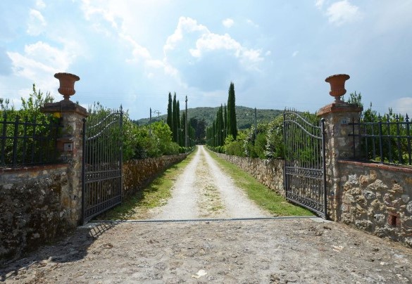 Entrance gate of the country house with an internal driveway bordered by rows of cypress trees – La Capanna di Franca 6+2