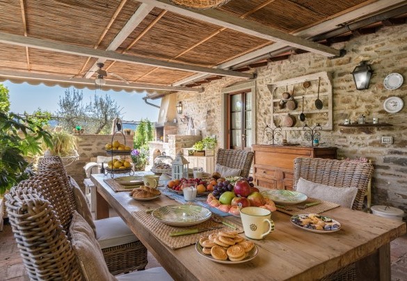 La veranda coperta ombreggia il tavolo preparato per colazioni all’aperto - La Capannina 