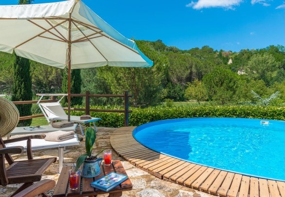 All around the pool is the stone-paved sunbathing area, bordered by hedges, with sunbeds and umbrella – La Casa dell’Artista 6