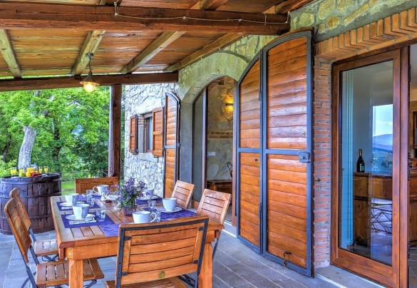 The porch shades the table prepared for outdoor breakfast – La Casa di Elsa 