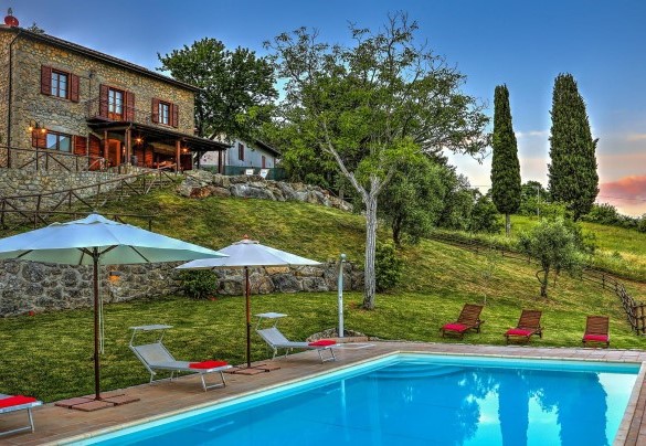 View of the pool, furnished with sunbeds and umbrellas, and the farmhouse in the background – La Casa di Elsa 