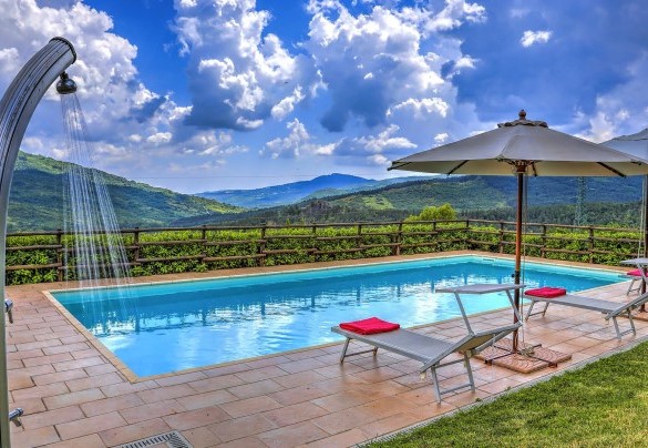 The outdoor lounge surrounded by green lawn and adjacent to the farmhouse – La Casa di Elsa 