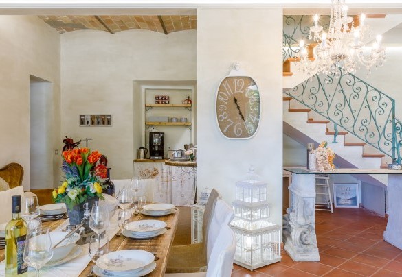 Accanto al tavolo da pranzo le scale permettono l'accesso al piano superiore - La casa di Nanì