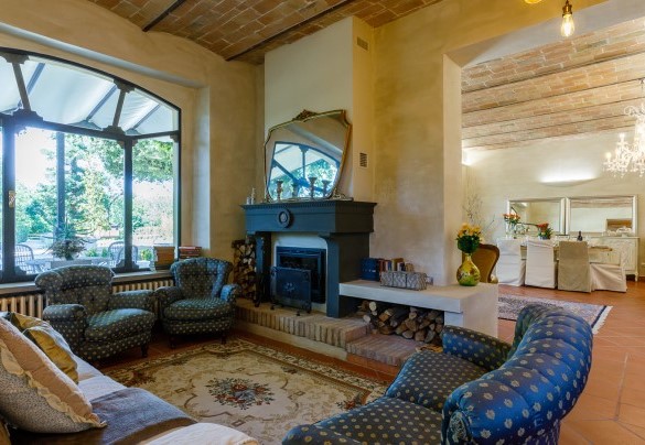 Il salotto principale dotato di caminetto e svariati divani - La casa di Nanì