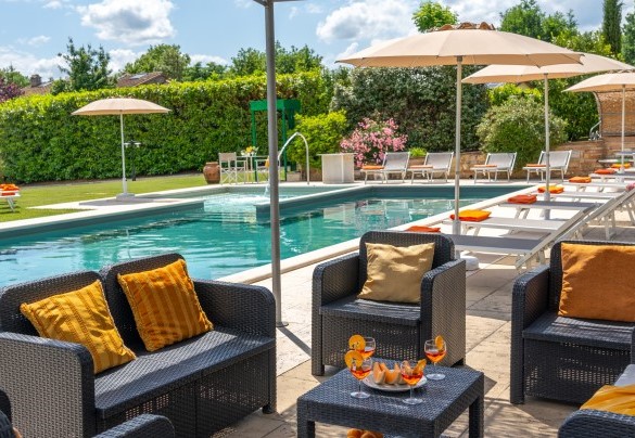 The pool and the sunbath area set up with sunbeds, tables, umbrellas, gazebo and shower - La Colonica