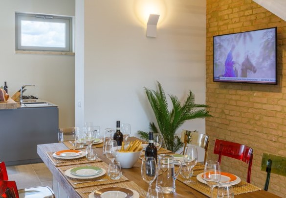 Il salotto, il tavolo da pranzo e la cucina in open plan – La Fonte di Santa Regina
