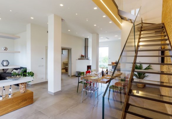 Nella seconda unità, articolata su due livelli, sono disposti, varcato l’ingresso principale, un salotto, il tavolo da pranzo e la cucina in open plan – La Fonte di Santa Regina