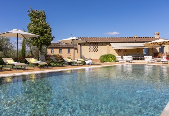 La suggestiva piscina a sfioro, una vista a perdita d’occhio che inquadra in lontananza i profili della città di Siena e della torre del Mangia – La Fonte di Santa Regina