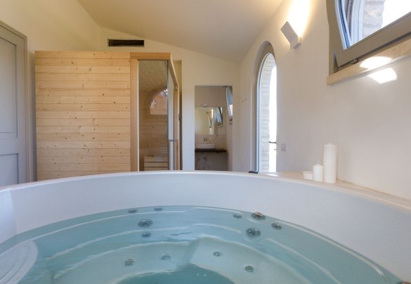 La zona benessere con vasca idromassaggio riscaldata, la sauna e un bagno con doccia – La Fonte di Santa Regina