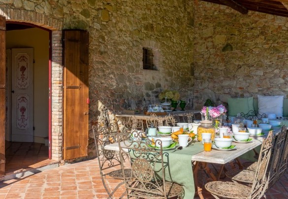 The portico shades the elegant table prepared for outdoor breakfast - La Mandolata  