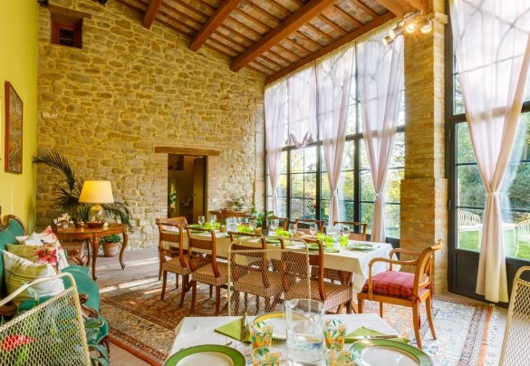 The veranda is furnished with tables, chairs and a sofa - La Tana del Ghiro